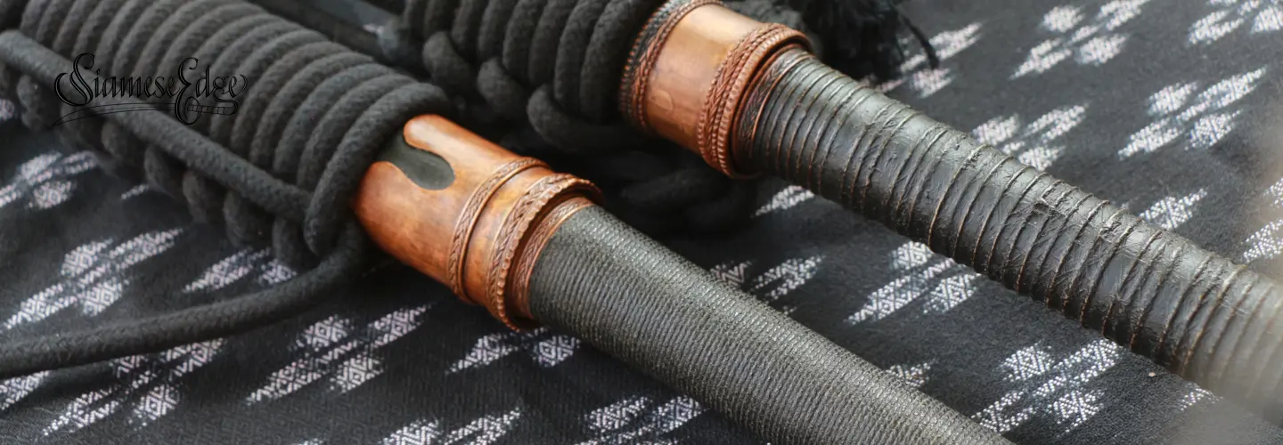 Close-up of the copper hilt fittings and braided cord on the wrapped grip