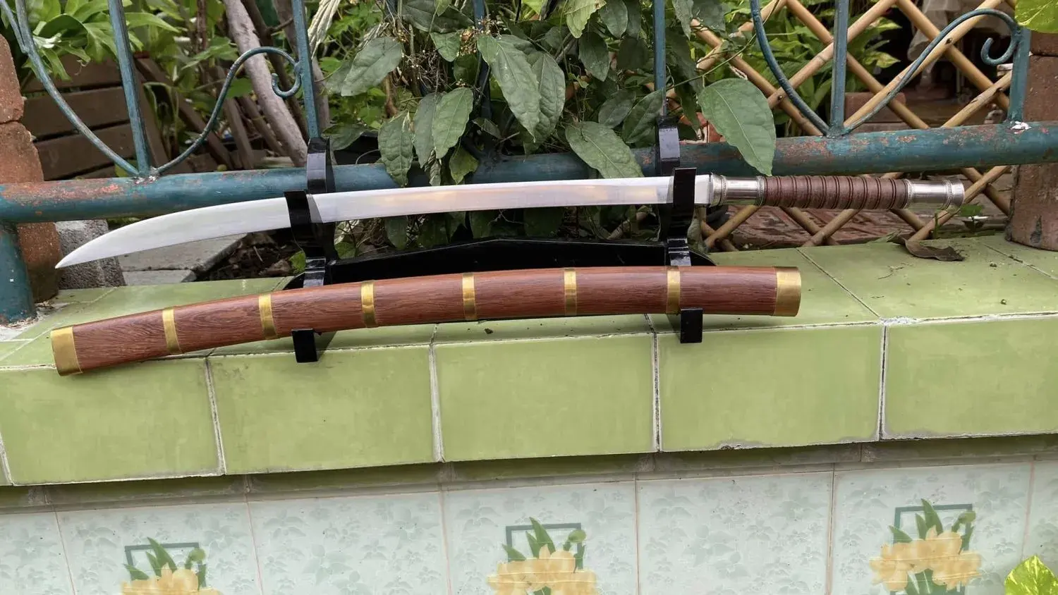 Custom build: long brown wrapped handle with white-metal fittings and a red-brown hardwood scabbard with brass bands