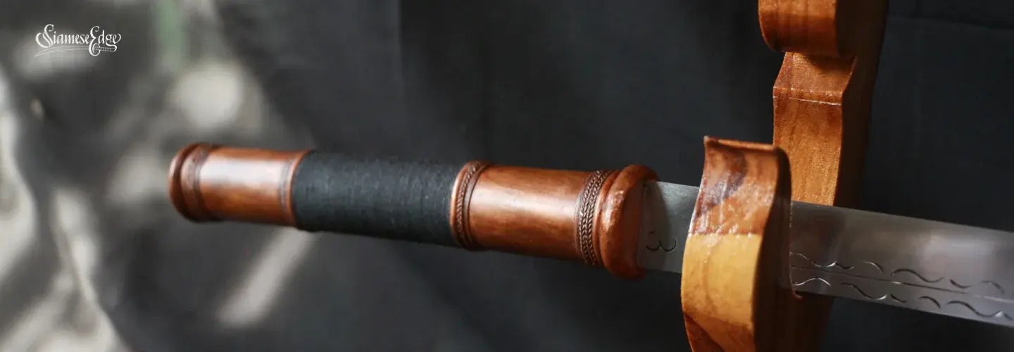 Handle close-up: black cotton wrap between a copper collar and cap, stamped blade beside it