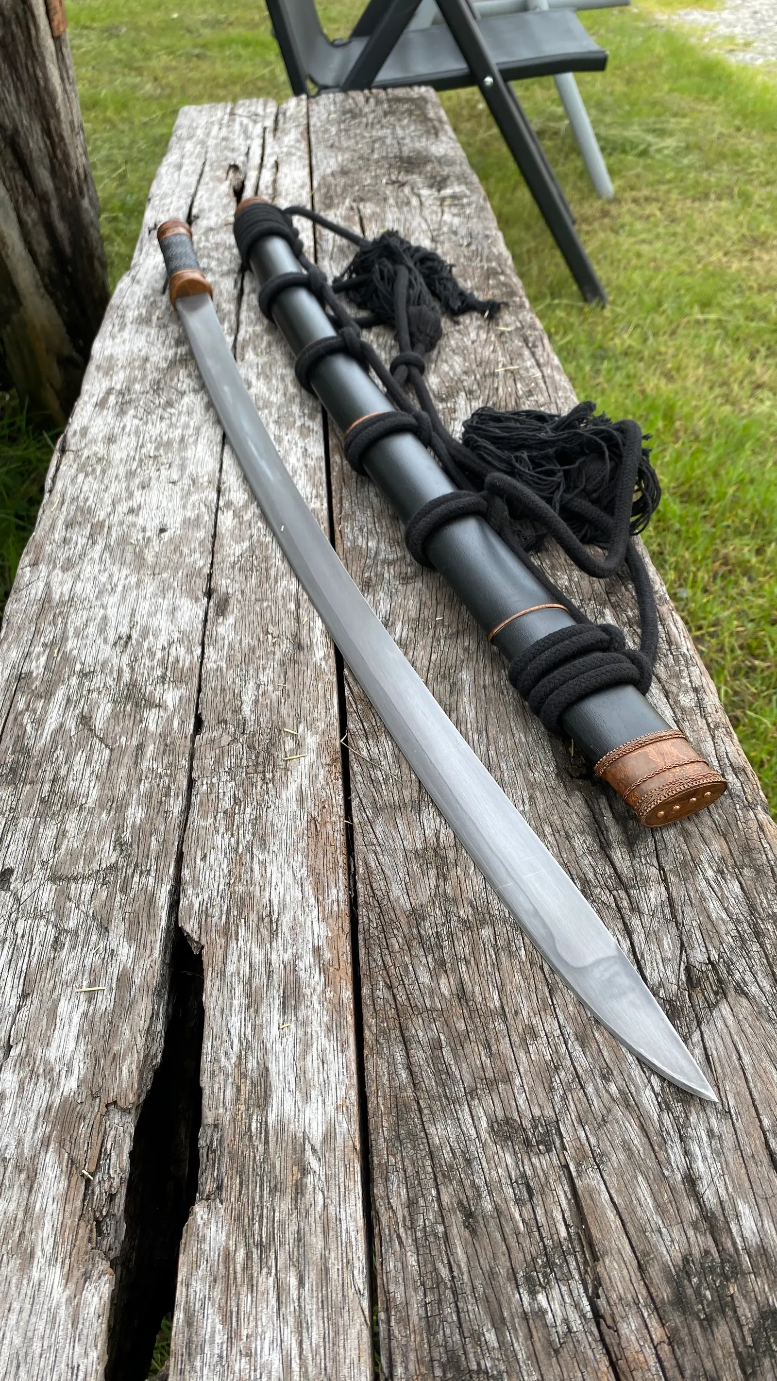 The sword above the scabbard and rope, with the blade tip.