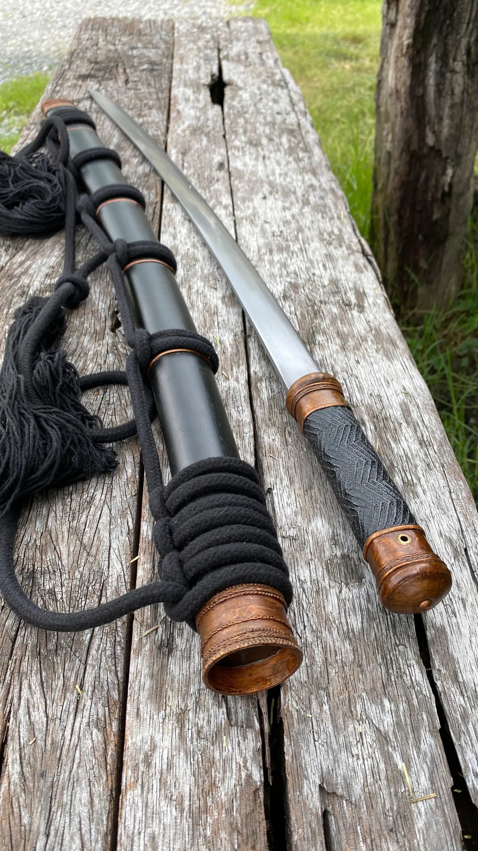 The sword lying on its scabbard with the rope coiled around it.