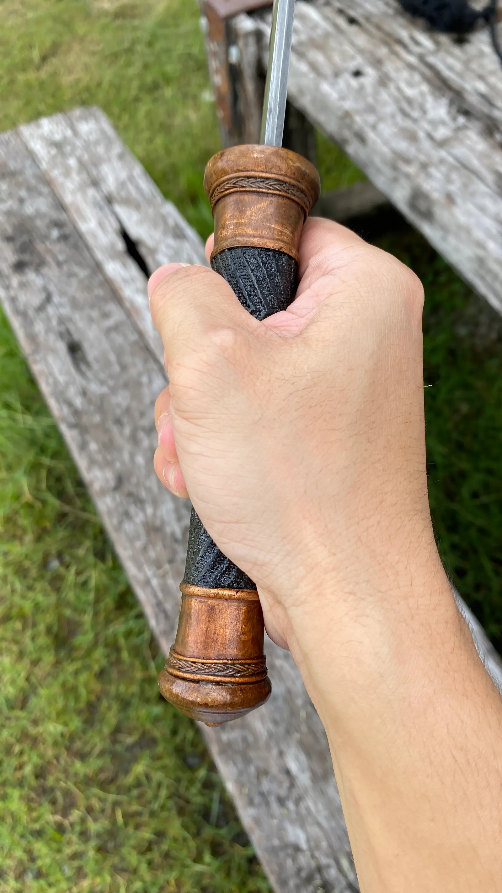 The grip in the hand: braided black lacquered handle and copper end cap.