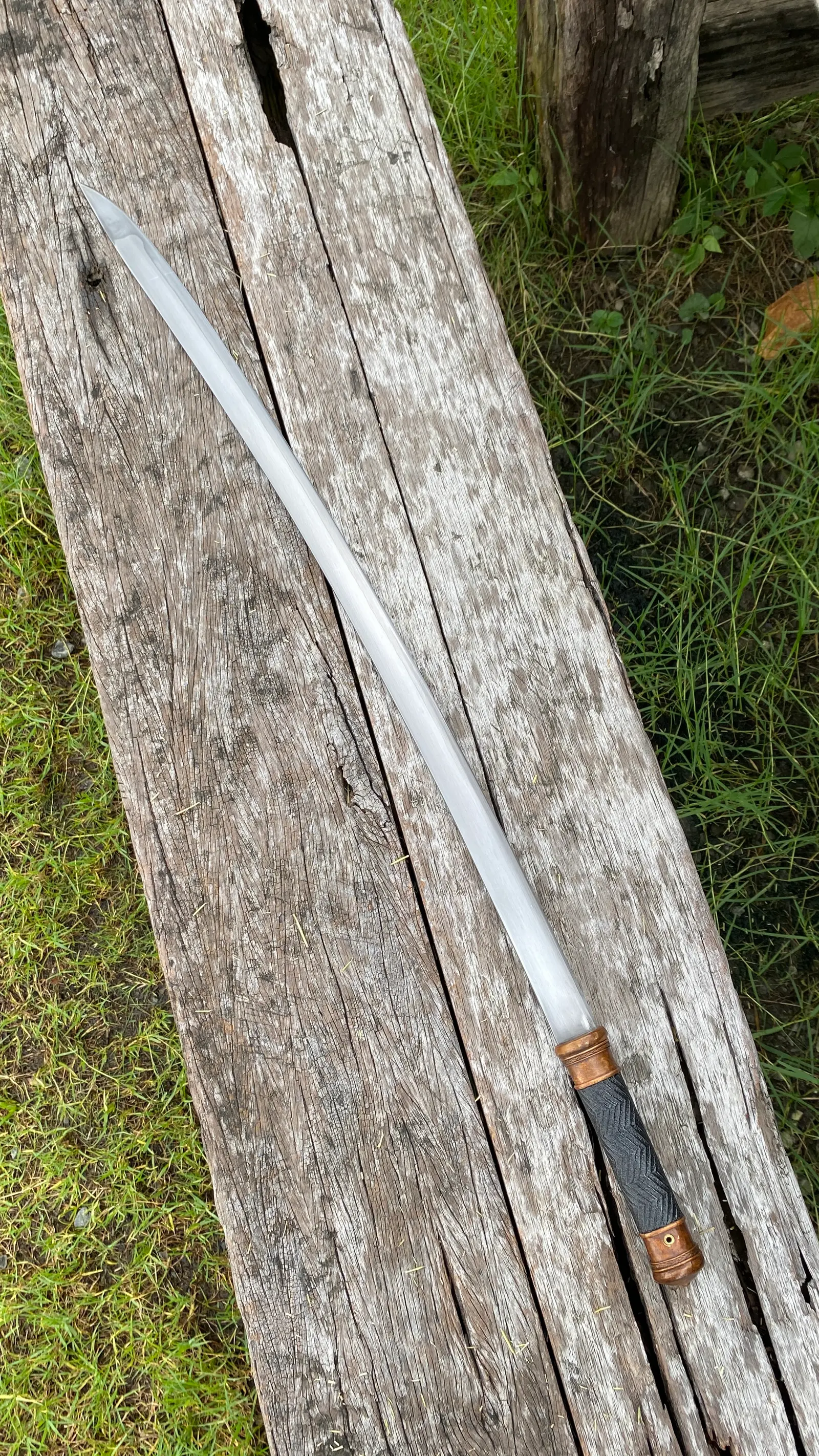 The drawn sword alone, full length, showing the gentle curve.