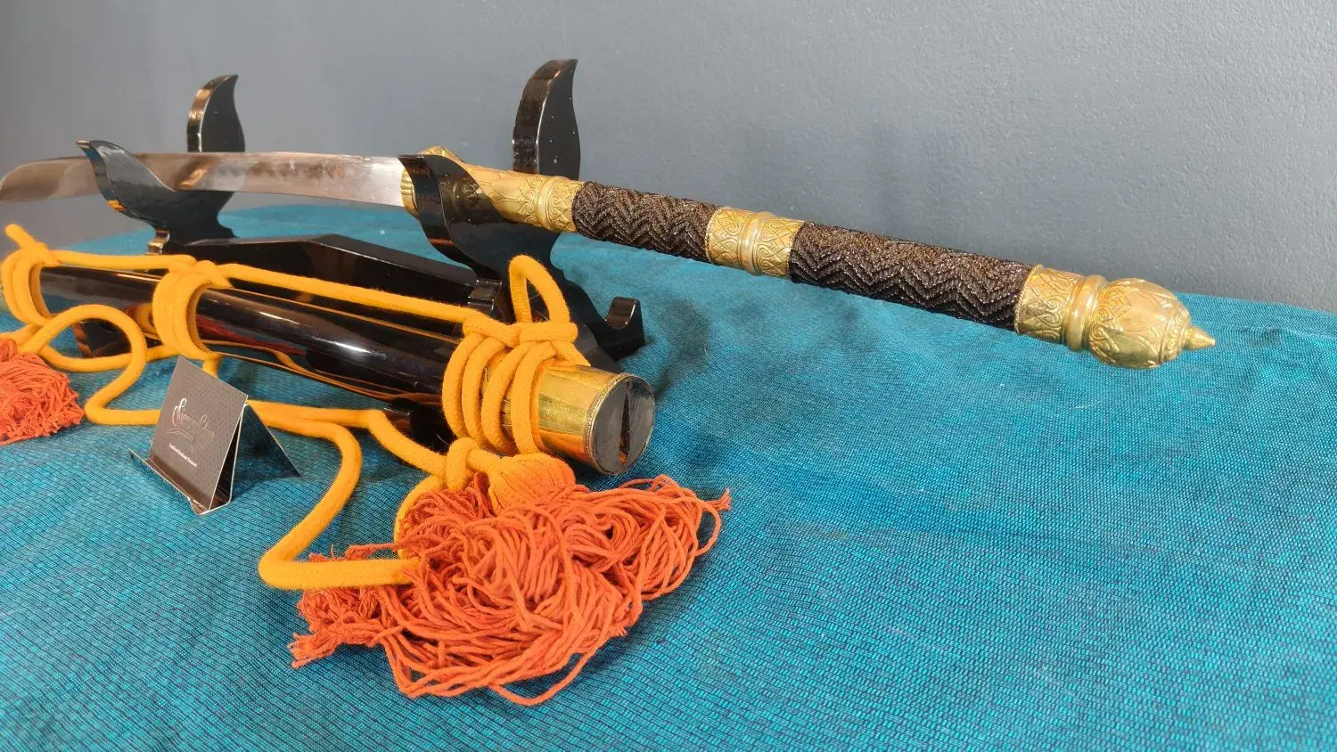 Close-up of the braided grip, brass middle band and lotus-bud pommel.