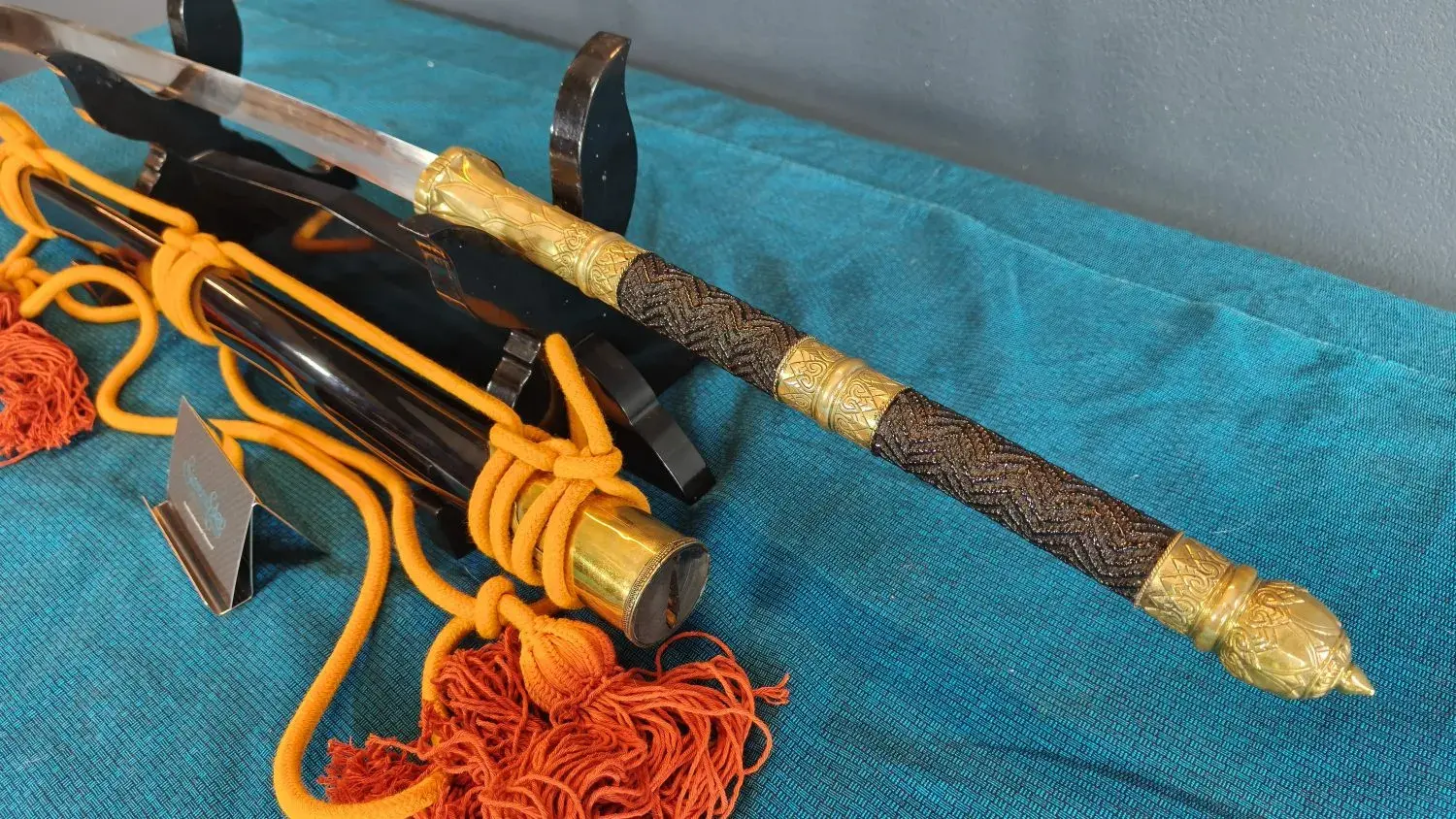 The grip and pommel seen from the other side, with the scabbard behind.