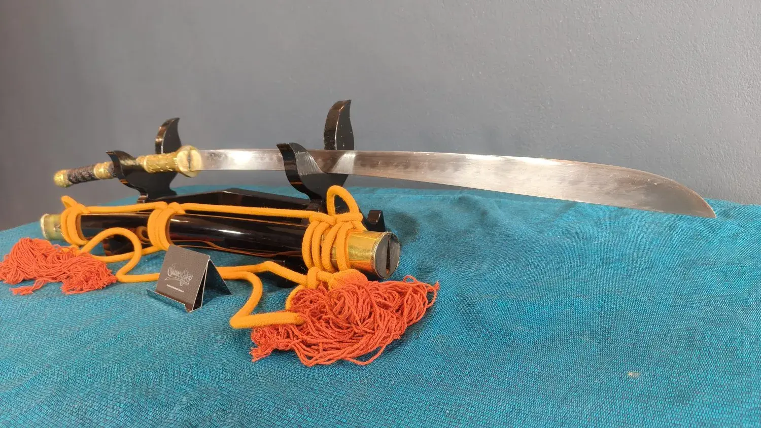Full side view of the sword on its stand from another angle.