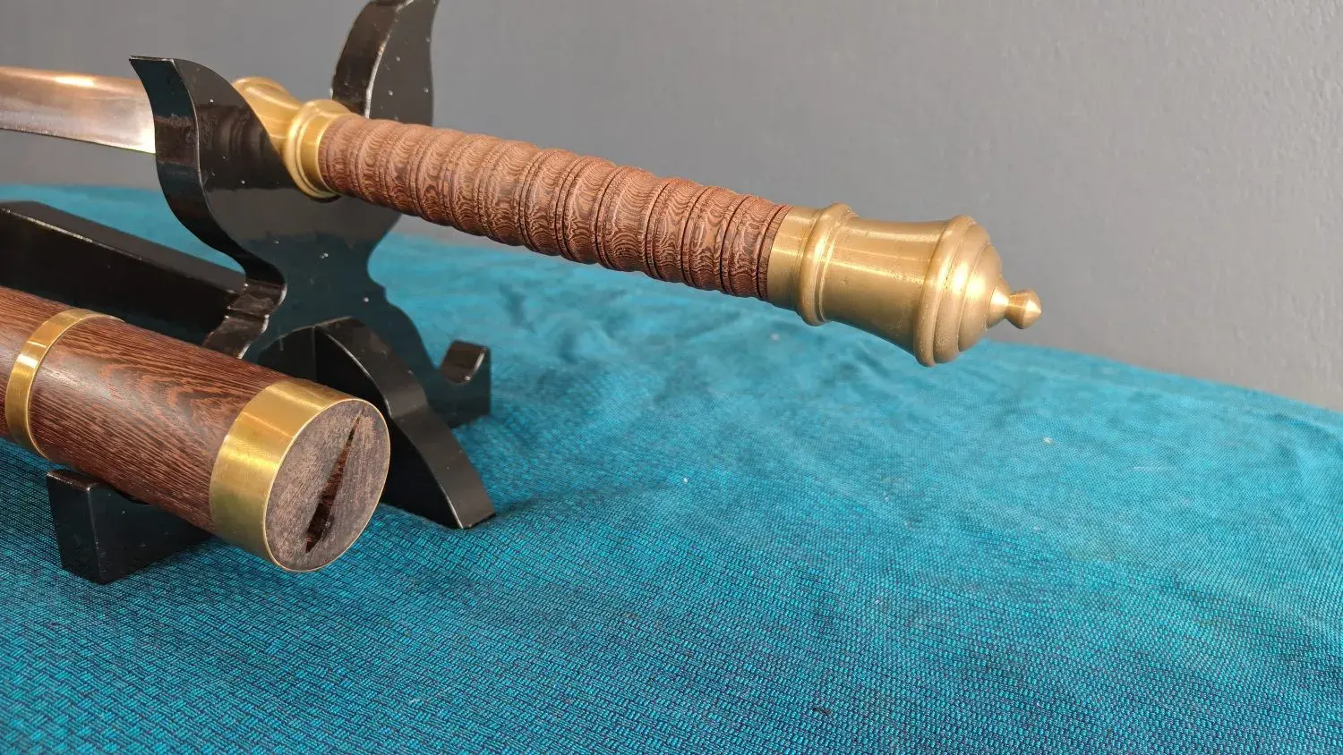 Close-up of the ringed rosewood grip, brass collar and stepped pommel