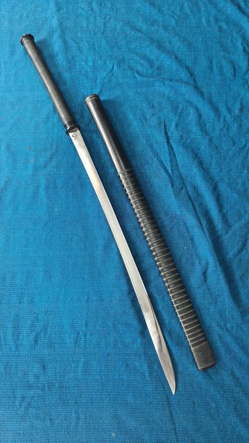EcoLine Thai–Laos: the sword drawn beside its black cord-banded scabbard on teal cloth