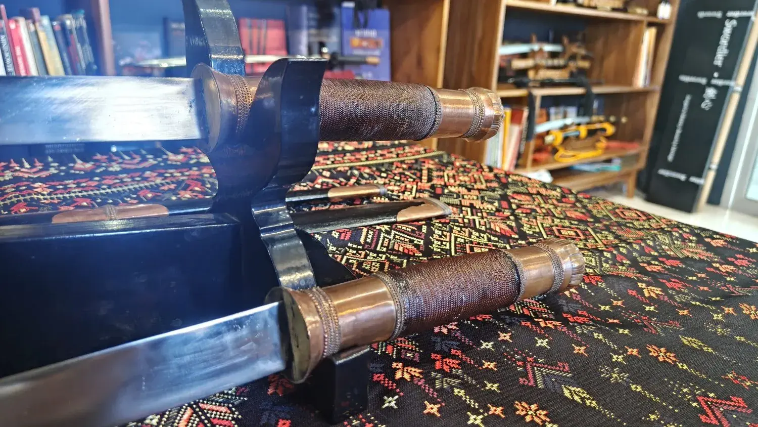 Tai Dhaab handle close-up: wrapped grips, copper collars and pommel caps
