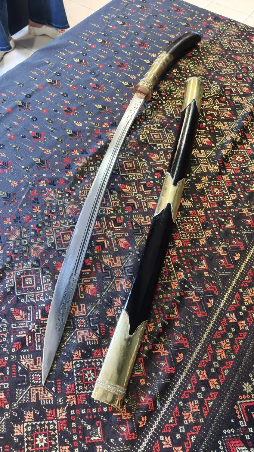 Tai–Lao style Dhaab with brass fittings, drawn beside its black scabbard with brass throat and chape